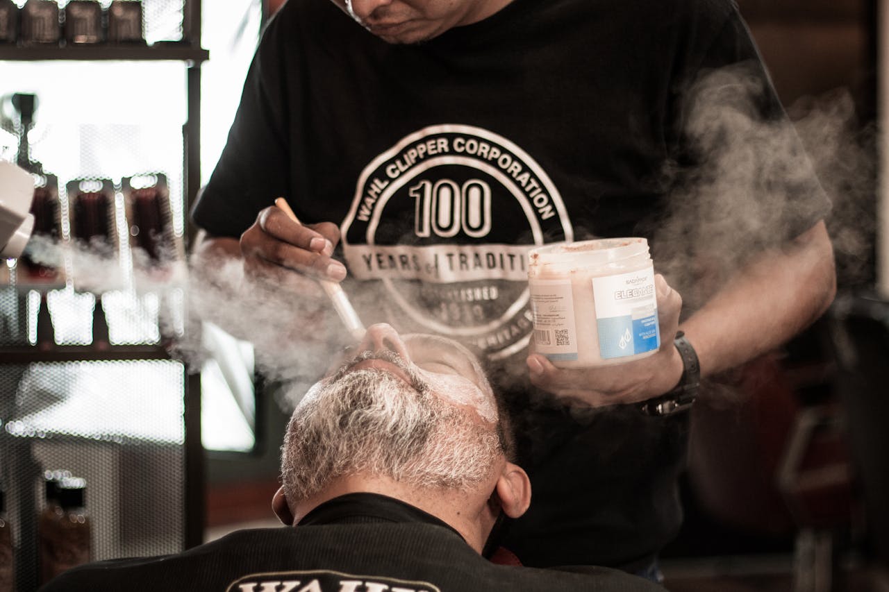 Close-up of a relaxed man receiving beard care in a traditional barbershop setting.