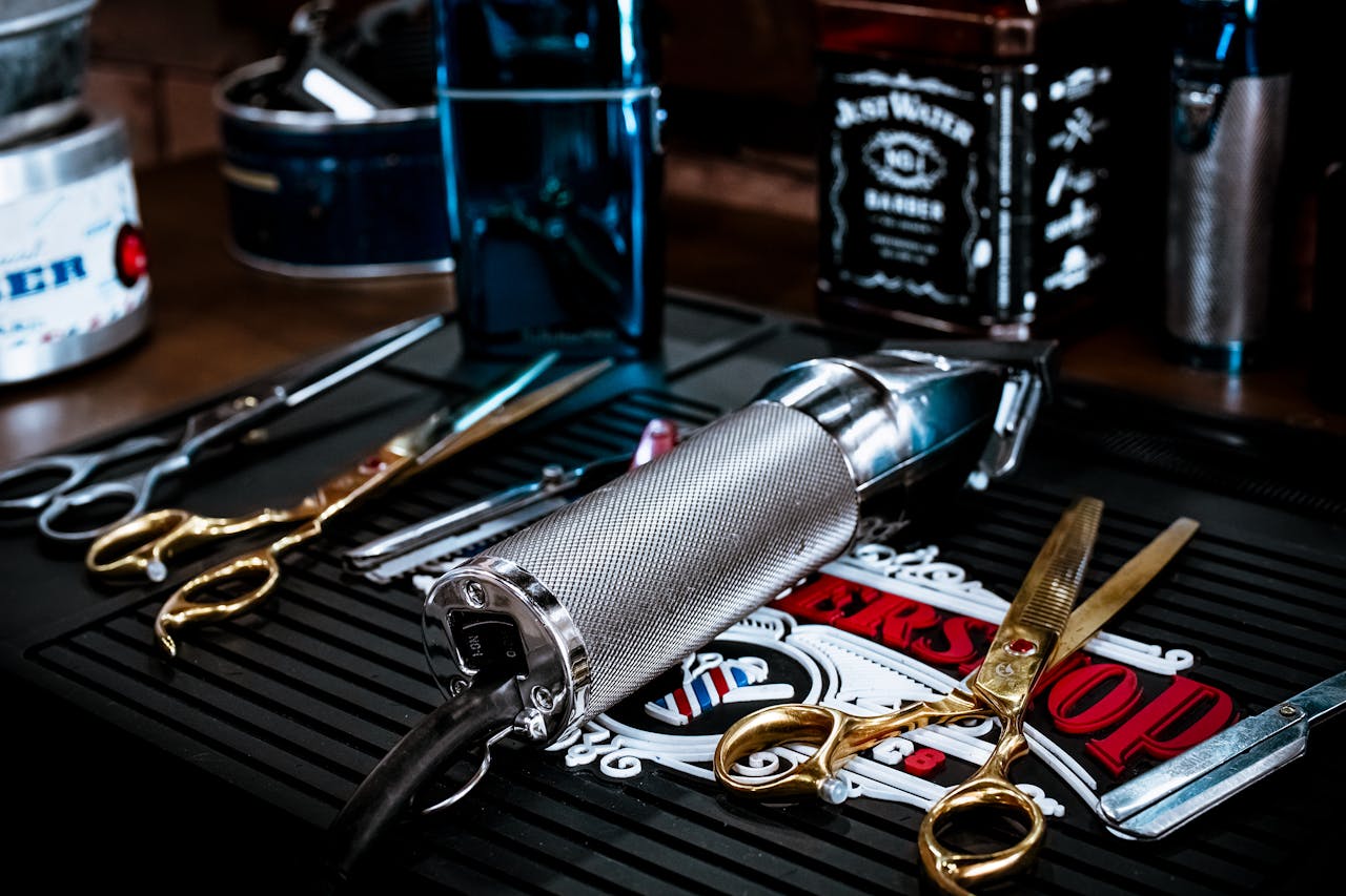 A close view of barber tools including scissors and clippers on a shop countertop.