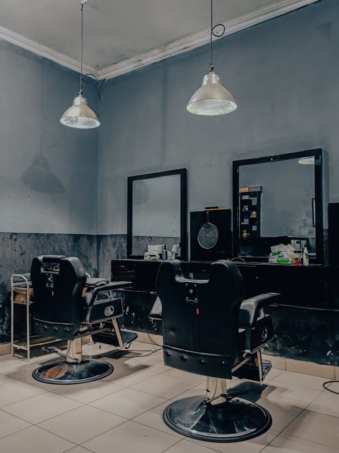 Cozy vintage-style barbershop interior in Indonesia with empty barber chairs and mirrors.